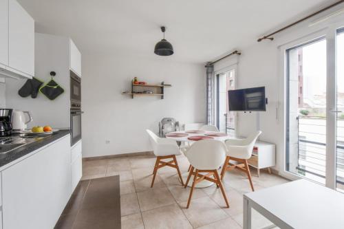 eine Küche und ein Esszimmer mit Tisch und Stühlen in der Unterkunft Appartement Veil - Welkeys in Clichy
