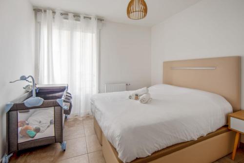 ein Schlafzimmer mit einem Bett und einem Babybett in der Unterkunft Appartement Veil - Welkeys in Clichy