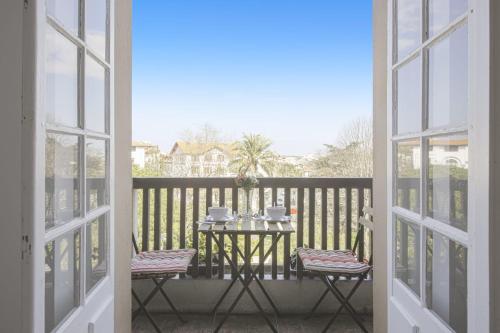 a table on a balcony with a table and two chairs at Studio Limpo - Welkeys in Hendaye