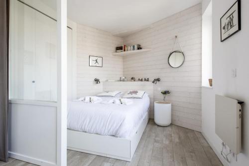a white bedroom with a bed and a mirror at Studio Limpo - Welkeys in Hendaye