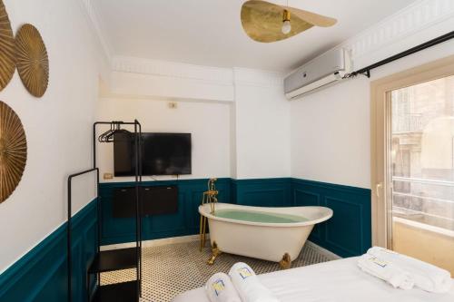 ein Badezimmer mit einer Badewanne und einem TV an der Wand in der Unterkunft The Neat Nostalgic 1BDR Studio Cairo's Downtown in Kairo