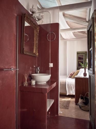 a bathroom with a sink and a mirror and a bed at Aria Villa in Agios Nikolaos