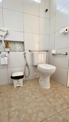 a bathroom with a white toilet in a room at Chacara do Alemao in Flecheiras