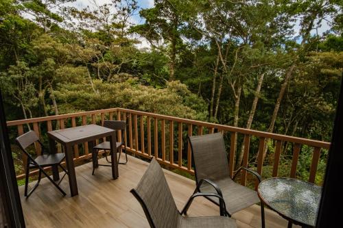 eine Holzterrasse mit einem Tisch und Stühlen darauf in der Unterkunft Casa Clusia in Monteverde Costa Rica