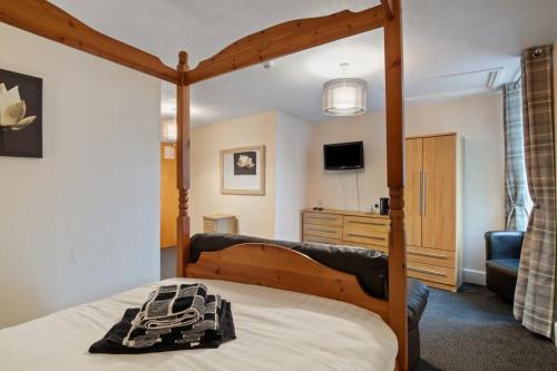 a bedroom with a bed with a wooden bed frame at Castle Hotel Haverfordwest in Haverfordwest
