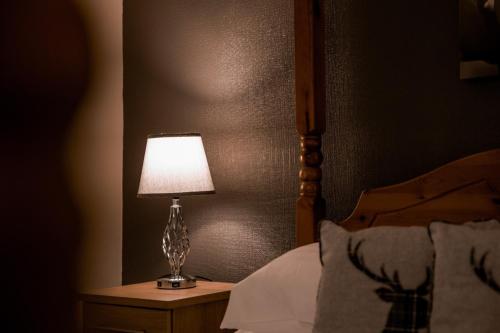 a lamp sitting on a night stand next to a bed at Castle Hotel Haverfordwest in Haverfordwest