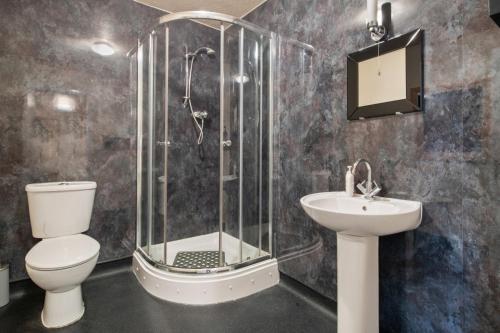 a bathroom with a shower and a toilet and a sink at Castle Hotel Haverfordwest in Haverfordwest