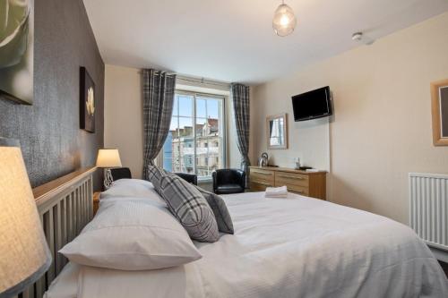 - une chambre avec un grand lit et une fenêtre dans l'établissement Castle Hotel Haverfordwest, à Haverfordwest