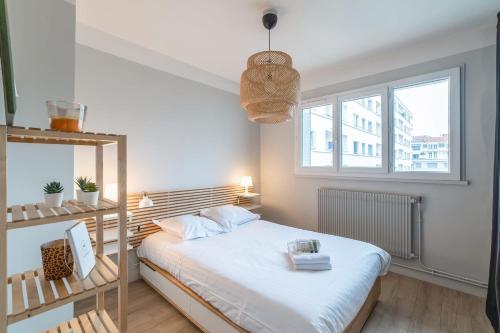 une petite chambre avec un lit et une fenêtre dans l'établissement Appartement de la Bannière - Welkeys, à Lyon