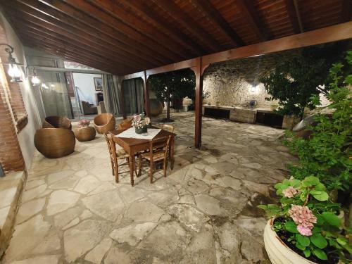 een patio met een tafel en stoelen op een stenen patio bij Evanthia's Stone House in Koilani