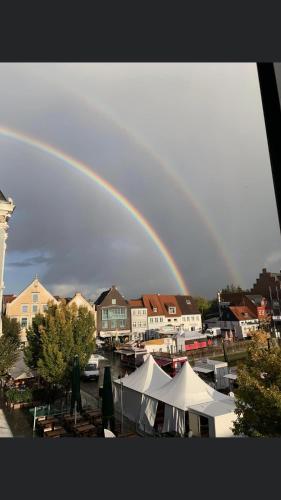 a rainbow in the sky over a town with boats at Monteurzimmer, Innenstadt Lage in Husum
