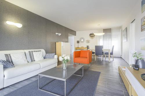 uma sala de estar com um sofá branco e uma mesa em Nice flat with terrace and parking - Biarritz - Welkeys em Biarritz
