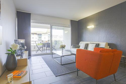 a living room with a couch and a table at Nice flat with terrace and parking - Biarritz - Welkeys in Biarritz