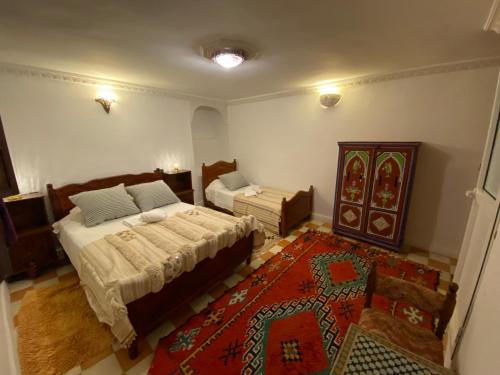 een slaapkamer met 2 bedden en een tapijt bij Dar benelmahi in Fès