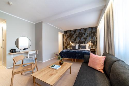 a living room with a bed and a couch at Hotel Sparre in Porvoo