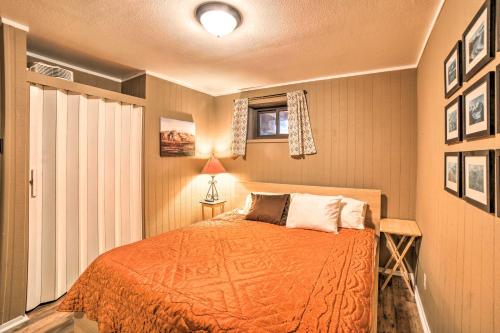 a bedroom with a bed with an orange blanket at Rustic Condo with Patio Walk to Angel Fire Resort! in Angel Fire