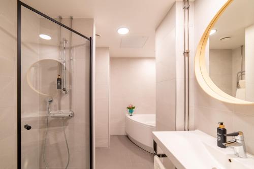 a bathroom with a shower and a sink and a mirror at Hotel Sparre in Porvoo