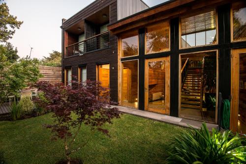 a house with large glass windows and a yard at Maki Hotel in Pucón