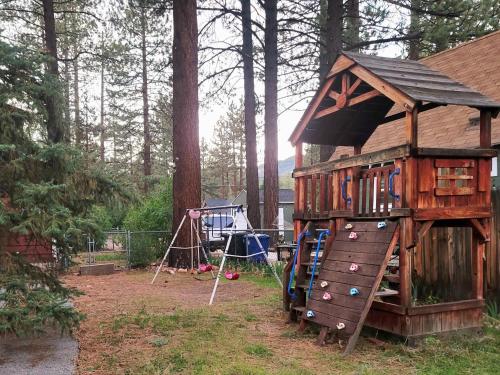 ビッグ・ベア・シティにあるGreen Cabin in Big Bear Lake 3 bdr Pets Friendlyの森の中の木の家がある遊び場