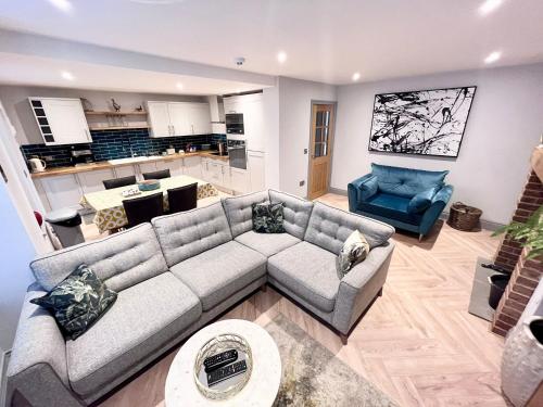 a living room with a couch and a kitchen at Olívia-Rojo in Cromer