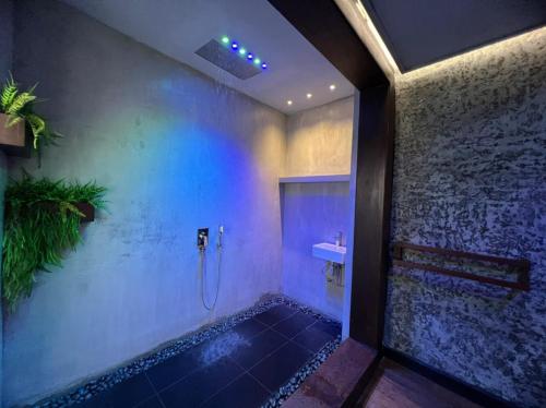 a bathroom with a shower with blue lights on the wall at Beverly Villa in Colombo