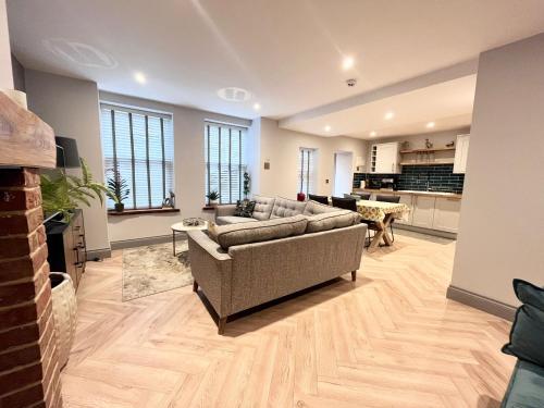 a large living room with a couch and a kitchen at Olívia-Rojo in Cromer