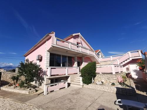 a pink house with a pathway in front of it at Guest house with pool Ante in Vrsi