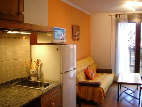 uma cozinha com um frigorífico e um sofá num quarto em Apartamento Valdesquí em Valdelinares
