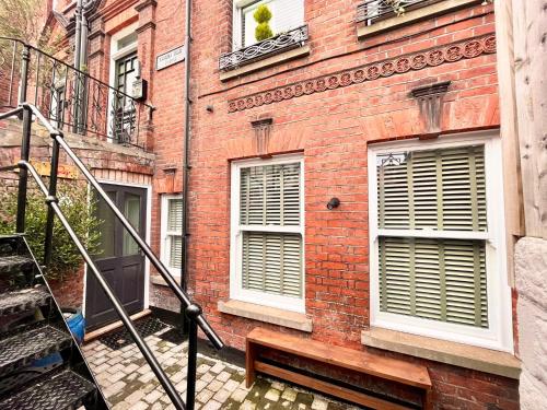 a brick building with a bench in front of it at Olívia-Rojo in Cromer