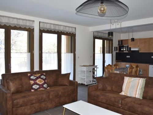 un salon avec deux canapés bruns et une cuisine dans l'établissement Bel appartement avec terrasse, proche du téléphérique et centre aquatique à Pralognan-la-Vanoise - FR-1-464-205, à Pralognan-la-Vanoise