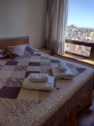 1 cama con 2 toallas y ventana en Departamento Corrientes Av. en Buenos Aires