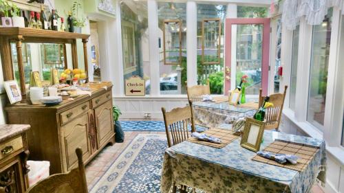 a dining room with a table and chairs and windows at The Old St Angela Inn in Pacific Grove