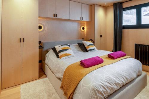 una camera da letto con un grande letto con due cuscini di L'Échappée Belle - Welkeys a La Clusaz