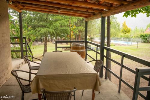 - une table et des chaises sur la terrasse couverte d'une maison dans l'établissement El Pinar Suizo, à Cacheuta