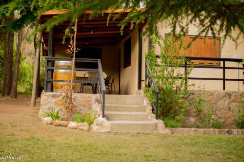 a house with stairs and a porch with a table at El Pinar Suizo in Cacheuta