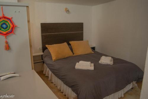 a bedroom with a bed with two towels on it at El Pinar Suizo in Cacheuta