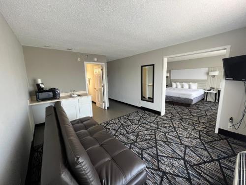 a living room with a couch and a bed at Baymont by Wyndham Peoria in Peoria