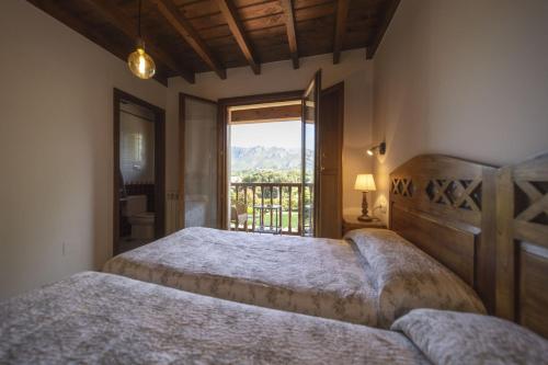 a bedroom with two beds and a large window at Camín de Mañanga in Llanes