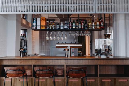 a bar with four stools in front of a counter at Südspeicher in Kappeln