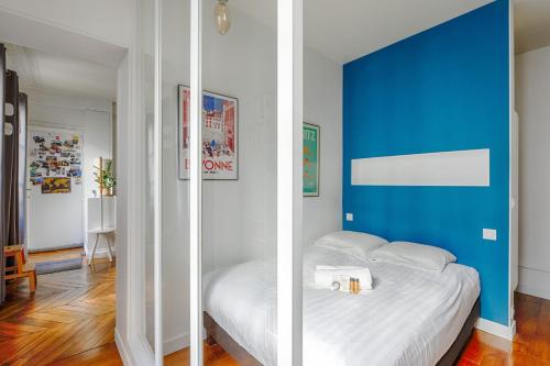 - une chambre avec un mur bleu et un lit dans l'établissement Appartement Fragonard - Welkeys, à Paris