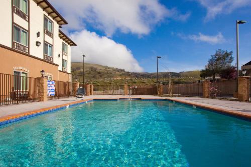 a large blue swimming pool next to a building at Holiday Inn Express & Suites Frazier Park, An IHG Hotel in Lebec