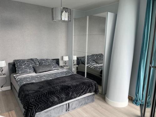 Apartament z widokiem na morze Międzyzdroje في مينززدرويه: غرفة نوم بسرير ومرآة