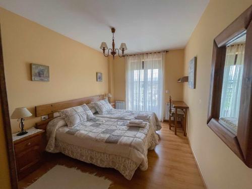 Un dormitorio con una cama grande y una ventana en La Nava de Gredos acogedor piso con vistas, en Navarredonda de Gredos