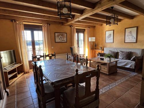 sala de estar con mesa y sofá en La Nava de Gredos acogedor piso con vistas, en Navarredonda de Gredos