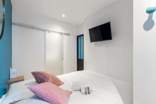 - une chambre avec un lit et une télévision murale dans l'établissement Appartement Macé - Welkeys, à Lyon
