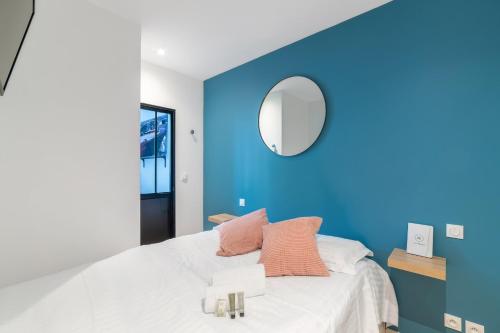 - une chambre bleue avec un lit et un miroir dans l'établissement Appartement Macé - Welkeys, à Lyon