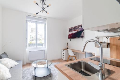 une cuisine avec un évier et un comptoir dans l'établissement Appartement Macé - Welkeys, à Lyon