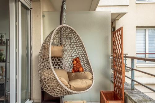 un ours en peluche assis dans un hamac suspendu dans l'établissement Studio Difesa - Welkeys, à Courbevoie