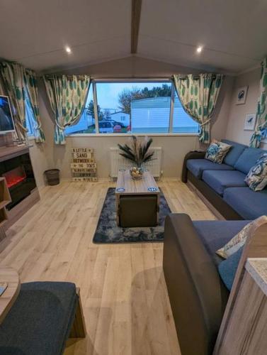sala de estar con sofá azul y TV en the fishing boat, en Port Seton