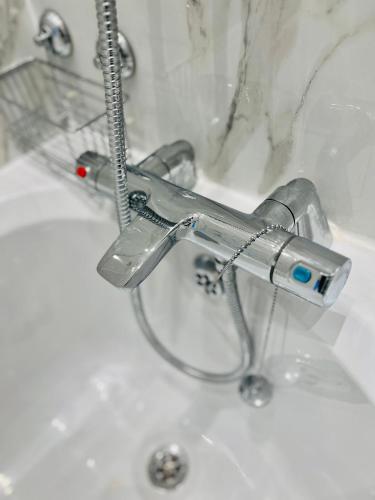 a bathroom sink with a faucet on top of it at Beautiful and Homely 3 Bed House With FREE Parking So Close To Man City and City Centre in Manchester